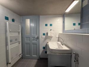 a white bathroom with a sink and a mirror at Dar el Maasser in Maasser El Chouf