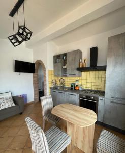 a kitchen with a wooden table and chairs in a room at Nenniri's house in Villamassargia