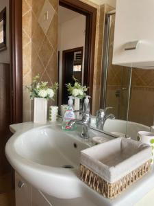 a bathroom with a white sink and a mirror at Nenniri's house in Villamassargia +10 photos