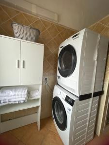 a washing machine sitting on top of a washer at Nenniri's house in Villamassargia
