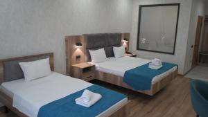 a hotel room with two beds and a window at Palace&Spa Rooms in Shymkent +94 photos