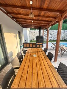 a wooden table and chairs in a patio with a grill at Villa Keyf Göcek in Fethiye