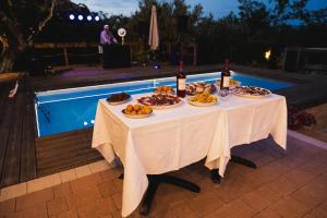 a table with food and drinks next to a pool at Villa Maria B&B in Marano Principato
