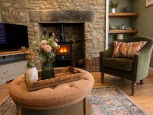 a living room with a fireplace and a chair at River Song, Aysgarth Falls in Leyburn