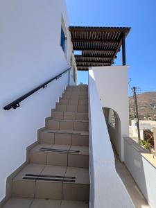a staircase leading up to a white building with a wooden roof at Ageon Amorgos in Amorgos +5 photos