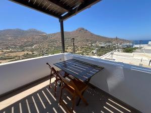 a table on a balcony with a view of the mountains at Ageon Amorgos in Amorgos