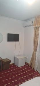 a room with a bed and a television on a wall at Одисей in Chişinău
