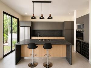 a kitchen with a large island with black counter tops at Villa horizonte in Playa del Carmen
