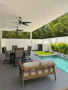a patio with a couch and a table and a pool at Villa horizonte in Playa del Carmen