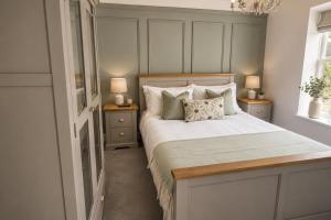 a bedroom with a bed with two night stands and two lamps at River Song, Aysgarth Falls in Leyburn