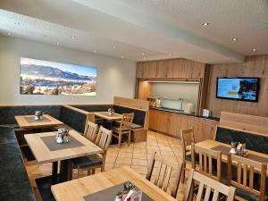 a restaurant with wooden tables and chairs and a kitchen at Gasthof - Restaurant Löcker in Radstadt