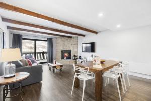 a living room with a table and chairs and a couch at Luxury Condominium with Rustic Minimalist Style in Mont-Tremblant