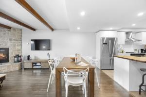 a kitchen and living room with a table and chairs at Luxury Condominium with Rustic Minimalist Style in Mont-Tremblant