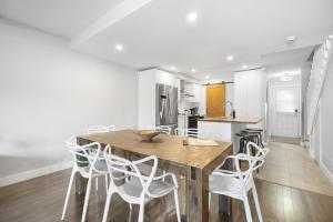 a kitchen with a wooden table and white chairs at Luxury Condominium with Rustic Minimalist Style in Mont-Tremblant +20 photos