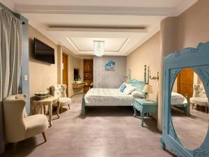 ein Schlafzimmer mit Bett, Spiegel und Stühlen in der Unterkunft Hotel Casa Ruth Cuenca in Cuenca + 66 Fotos