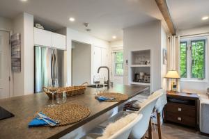 a kitchen with a large island with a table and chairs at Simple & Luxe Condo With View in Mont-Tremblant