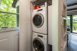a laundry room with a washer and dryer next to a window at Simple & Luxe Condo With View in Mont-Tremblant
