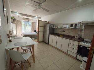 a kitchen with a table and chairs in a room at Apart Zeta in Belén de Escobar