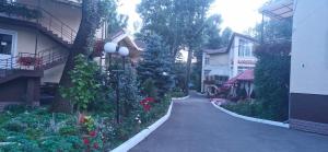 a walkway between two buildings with flowers and plants at Одисей in Chişinău