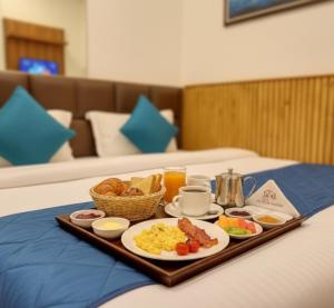 a tray of breakfast food on a bed at Hotel Church House - Rohini I Near Metro I Spacious Rooms I Friendly Staff I Most Preferred Hotel In Rohini in Delhi
