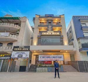 a man standing in front of a building at Hotel Church House - Rohini I Near Metro I Spacious Rooms I Friendly Staff I Most Preferred Hotel In Rohini in Delhi
