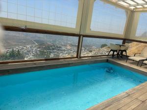 a swimming pool in a building with a view at צימר ענאן בגולן in Majdal Shams