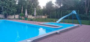 a blue slide in a swimming pool with a pool at Одисей in Chişinău