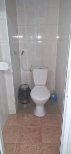 a white toilet in a bathroom with a shower at Одисей in Chişinău +14 photos