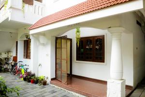 an open door of a white house with plants at GOOD KARMA INN Apartment in Cochin