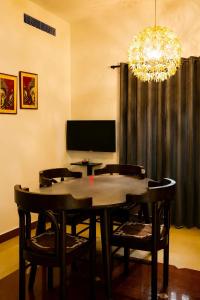 a dining room with a table and chairs and a chandelier at GOOD KARMA INN Apartment in Cochin