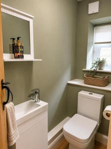 a bathroom with a white toilet and a sink at River Song, Aysgarth Falls in Leyburn +4 photos