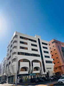 a large white building on a city street at Vogue Inn in Abu Dhabi
