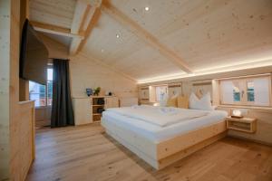 ein Schlafzimmer mit einem großen weißen Bett in einem Zimmer in der Unterkunft Pension Gerstenbrand in Fischbachau