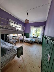 a bedroom with two bunk beds and purple walls at Karaby Gård, Country Living självhushåll in Kristinehamn