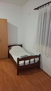 a bed sitting in a room with a window at Apartman Jezero in Trebinje