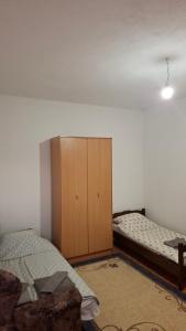 a bedroom with two beds and a cabinet in it at Apartman Jezero in Trebinje