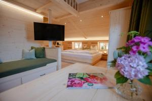 ein Zimmer mit zwei Betten und einem Tisch mit Blumen in der Unterkunft Pension Gerstenbrand in Fischbachau