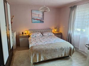 a bedroom with a bed and a large window at Rural accommodation Vidovic in Ugarci