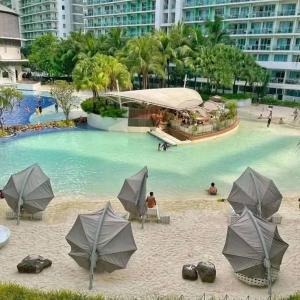 a beach with umbrellas and people in the water at SM Bicutan Quick Staycation PH in Manila