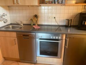 a kitchen with a stainless steel stove and a sink at Ferienwohnung - Missen-Wilhams Allgäu in Missen-Wilhams