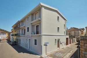 a white building on the side of a street at ARGHENTU Rooms in San Vito