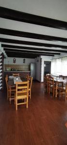 a dining room with wooden tables and wooden chairs at Rustic Argesean in Corbeni