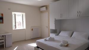a white bedroom with a white bed and a window at Il Rigoletto Casa Vacanze in Lamezia Terme