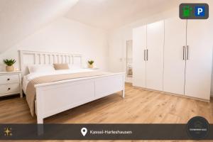 a white bedroom with a white bed and white cabinets at Ferienwohnung Kassel mit Ladesäule in Kassel