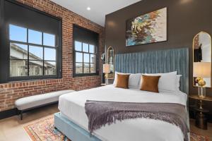 a bedroom with a large bed and a brick wall at Eleven48 Hotel in New Orleans