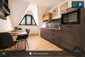 a kitchen with a table and a dining room at Ferienwohnung Kassel mit Ladesäule in Kassel +3 photos