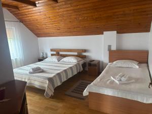 a bedroom with two beds and a wooden ceiling at Rustic Argesean in Corbeni