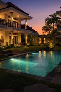 a swimming pool in front of a house at night at vila del paraíso in Castelldefels