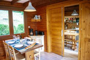 a dining room and kitchen in a log cabin at Chalet entier, vue panoramique, ruisseau et sauna. in Bussang