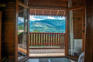 a screened in porch with a view of the mountains at Chalet entier, vue panoramique, ruisseau et sauna. in Bussang +65 photos